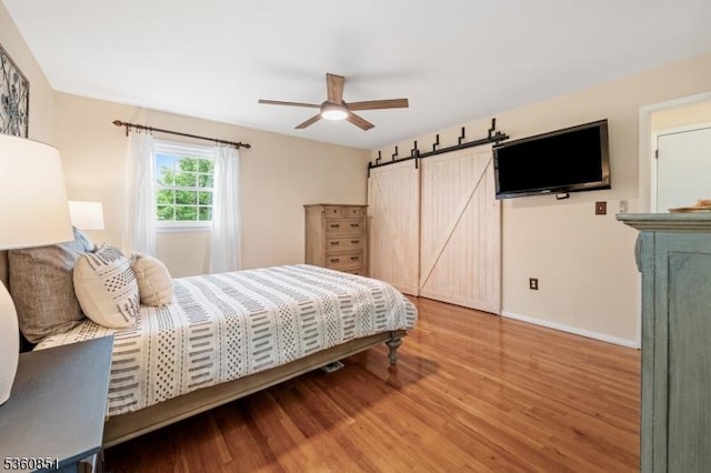 39 Fox Chase Run, Hillsborough Twp, NJ 08844 - bedroom with a barn door, wood finished floors, baseboards, and ceiling fan