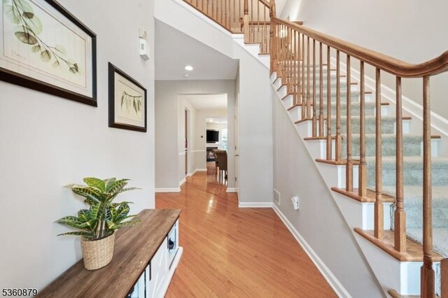 25 Kennedy Ct, Montgomery Twp, NJ 08540 - stairway featuring wood finished floors, baseboards, recessed lighting, and a towering ceiling