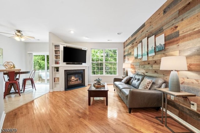 25 Kennedy Ct, Montgomery Twp, NJ 08540 - living area with healthy amount of natural light, a ceiling fan, light wood-type flooring, a glass covered fireplace, and wooden walls