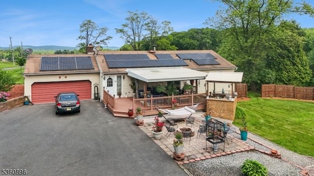 16 Hogback Rd, Franklin Twp, NJ 08867 - view of front of house featuring an attached garage, asphalt driveway, a wooden deck, and solar panels