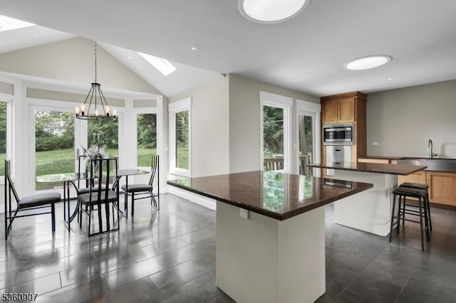 34 Keats Rd, Bernards Twp, NJ 07920 - kitchen with a center island, stainless steel microwave, a sink, dark countertops, and a chandelier