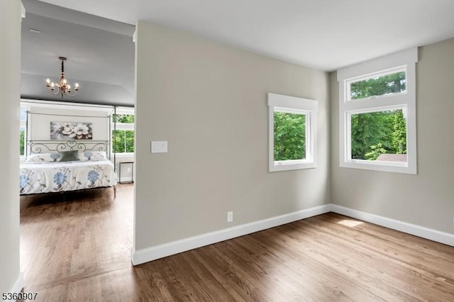 34 Keats Rd, Bernards Twp, NJ 07920 - unfurnished bedroom featuring multiple windows, a chandelier, baseboards, and wood finished floors