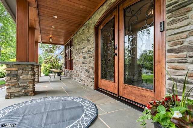 34 Keats Rd, Bernards Twp, NJ 07920 - view of exterior entry featuring stone siding, a porch, and french doors
