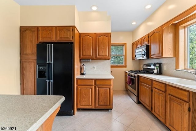10 Garden Pl, Cranford Twp, NJ 07016 - kitchen with stainless steel appliances, a sink, light countertops, backsplash, and brown cabinetry