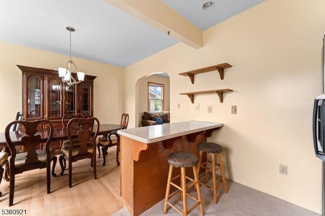 10 Garden Pl, Cranford Twp, NJ 07016 - kitchen with arched walkways, a kitchen breakfast bar, a peninsula, open shelves, and light countertops