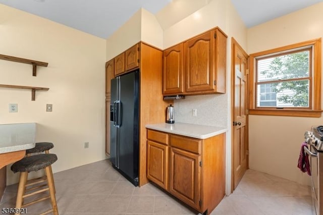 10 Garden Pl, Cranford Twp, NJ 07016 - kitchen with black refrigerator with ice dispenser, brown cabinets, light countertops, and light tile patterned floors