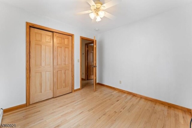 10 Garden Pl, Cranford Twp, NJ 07016 - unfurnished bedroom featuring light wood-type flooring, baseboards, a baseboard radiator, a closet, and ceiling fan