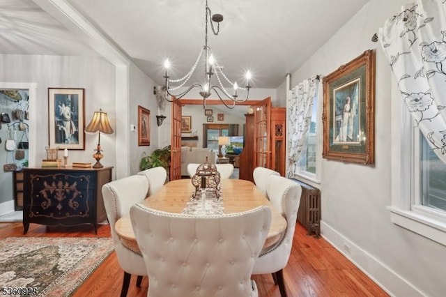 2 Broad St, Stockton Boro, NJ 08559 - dining space with radiator, a chandelier, wood finished floors, and baseboards