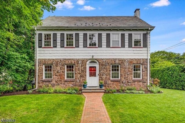 168 Grove St, Montclair Twp, NJ 07042 - view of front facade with stone siding, a front lawn, and a chimney