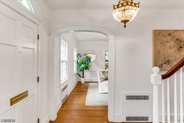 168 Grove St, Montclair Twp, NJ 07042 - foyer entrance with arched walkways, light wood-style flooring, ornamental molding, heating unit, and baseboards