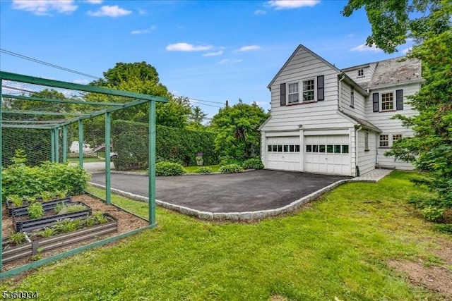 168 Grove St, Montclair Twp, NJ 07042 - view of green lawn with a garden, a garage, and asphalt driveway