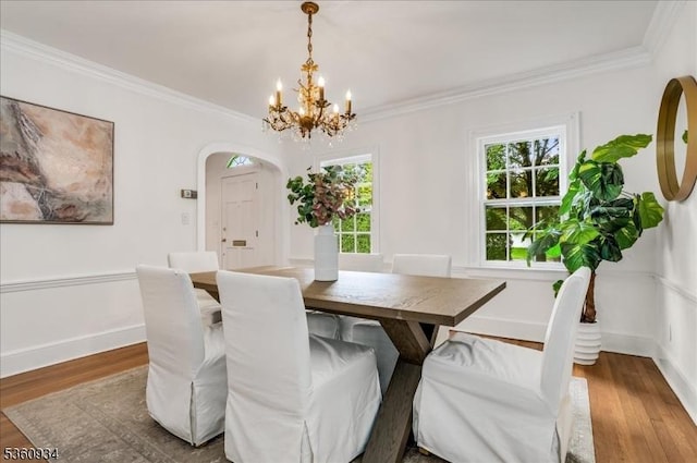168 Grove St, Montclair Twp, NJ 07042 - dining space featuring a chandelier, arched walkways, wood finished floors, crown molding, and baseboards