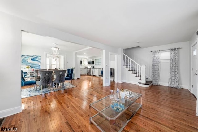 770 Stone St, Rahway City, NJ 07065 - living area with stairs, a chandelier, wood finished floors, and baseboards