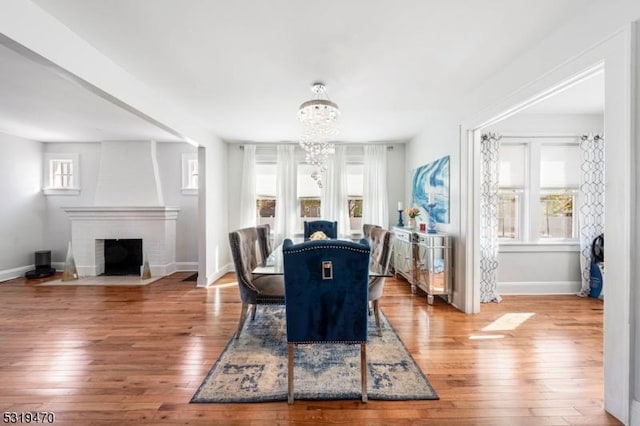 770 Stone St, Rahway City, NJ 07065 - dining room with a chandelier, wood-type flooring, baseboards, and a brick fireplace