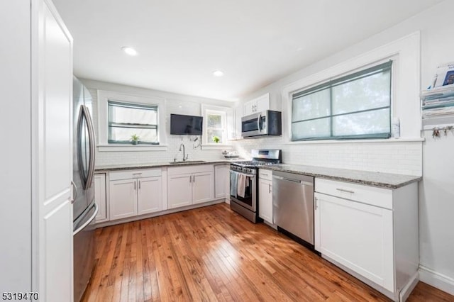 770 Stone St, Rahway City, NJ 07065 - kitchen featuring appliances with stainless steel finishes, a sink, decorative backsplash, light wood-style flooring, and recessed lighting