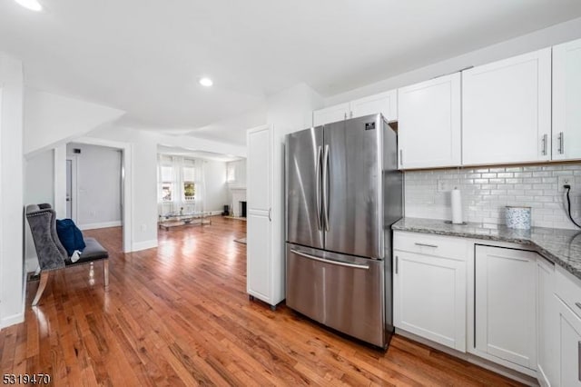 770 Stone St, Rahway City, NJ 07065 - kitchen featuring freestanding refrigerator, light wood-type flooring, tasteful backsplash, light stone countertops, and white cabinetry