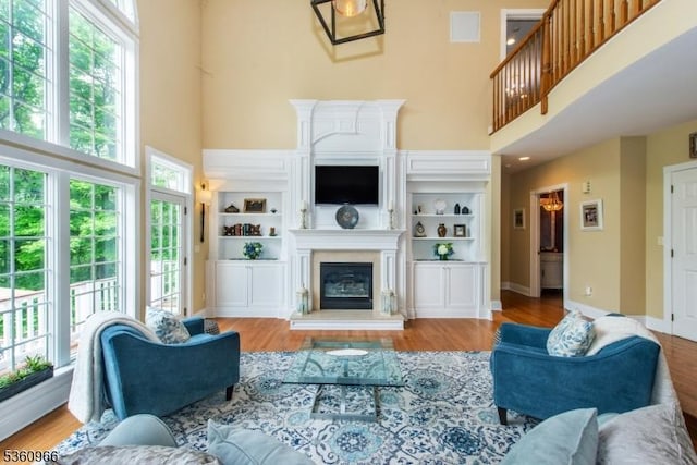 7 Briscoe Chase, Ringwood Boro, NJ 07456 - living room with a towering ceiling, a glass covered fireplace, plenty of natural light, and wood finished floors