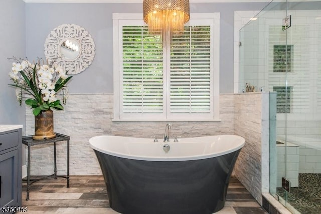 7 Briscoe Chase, Ringwood Boro, NJ 07456 - full bathroom with tile walls, a chandelier, a soaking tub, a stall shower, and wood finished floors