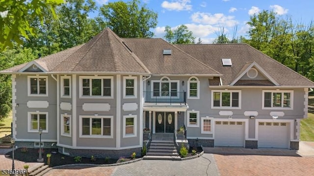 47 Cutlass Rd, Kinnelon Boro, NJ 07405 - view of front facade with a balcony, decorative driveway, a garage, stucco siding, and roof with shingles