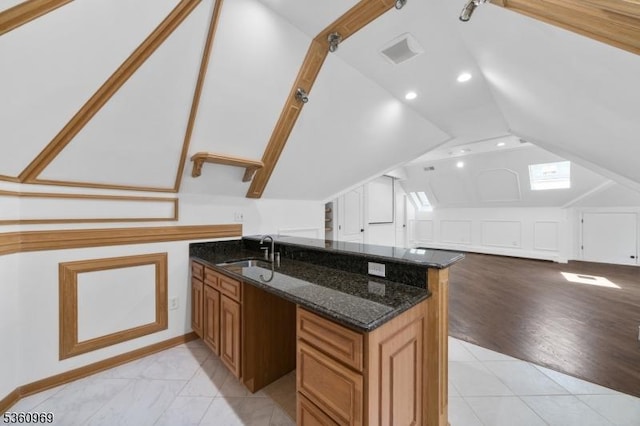 47 Cutlass Rd, Kinnelon Boro, NJ 07405 - kitchen with a sink, lofted ceiling, brown cabinetry, dark stone counters, and open floor plan