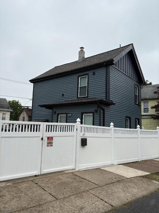 41-43 N 11th St, Paterson City, NJ 07522 - view of front of home featuring board and batten siding, a gate, and a chimney