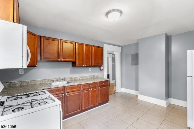 489 Conover Ter, City Of Orange Twp, NJ 07050 - kitchen featuring white appliances, a sink, light countertops, baseboards, and brown cabinets