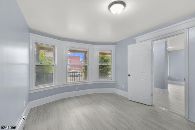 489 Conover Ter, City Of Orange Twp, NJ 07050 - empty room with baseboards, light wood finished floors, and a baseboard radiator