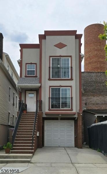 648 Marshall St, Elizabeth City, NJ 07206 - view of front facade featuring concrete driveway, a garage, and stucco siding