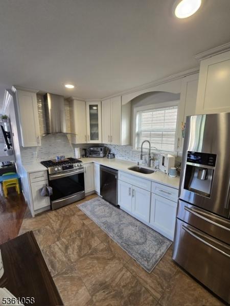 648 Marshall St, Elizabeth City, NJ 07206 - kitchen with appliances with stainless steel finishes, wall chimney exhaust hood, a sink, backsplash, and white cabinetry