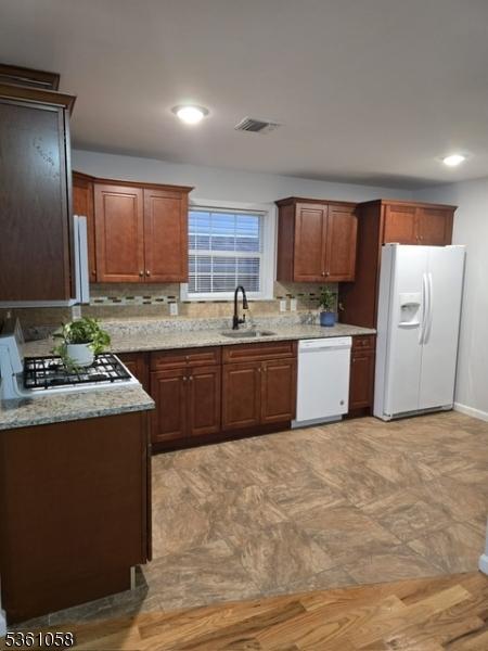648 Marshall St, Elizabeth City, NJ 07206 - kitchen with white appliances, a sink, decorative backsplash, light stone counters, and recessed lighting