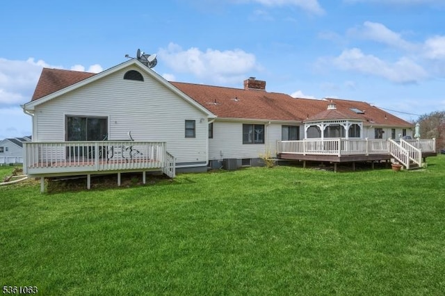 30 Claridge Ln, Raritan Twp, NJ 08822 - rear view of house featuring a wooden deck, a chimney, a lawn, and roof with shingles
