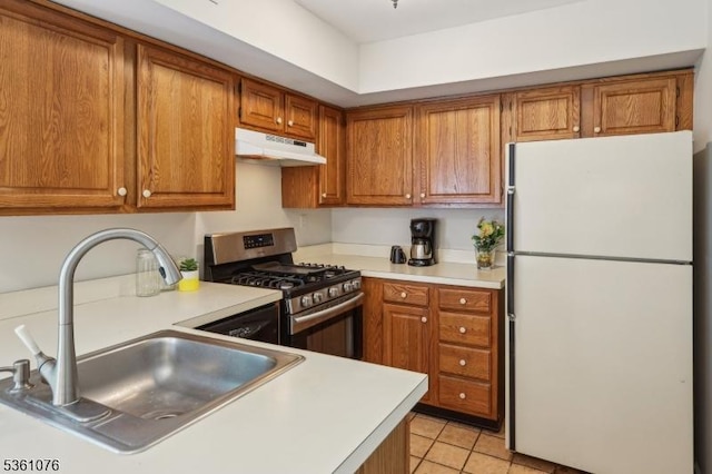 261 Bloomsbury Ct, Franklin Twp, NJ 08873 - kitchen with freestanding refrigerator, stainless steel range with gas cooktop, under cabinet range hood, a sink, and brown cabinets