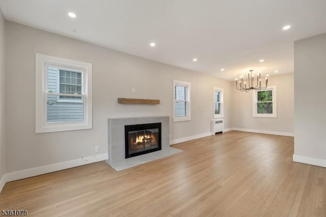 1535 Leslie St, Hillside Twp, NJ 07205 - unfurnished living room featuring radiator heating unit, a chandelier, a fireplace with flush hearth, light wood-style flooring, and baseboards