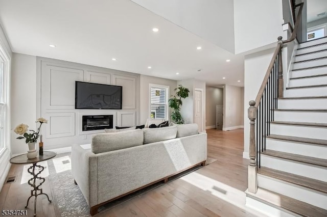 223 Victor St, Scotch Plains Twp, NJ 07076 - living room with stairs, a glass covered fireplace, light wood finished floors, recessed lighting, and baseboards