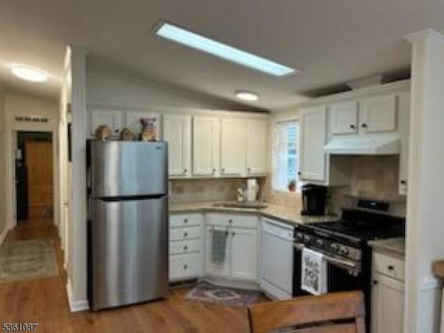 512 Kenbury Rd, Branchburg Twp, NJ 08876 - kitchen with stainless steel appliances, under cabinet range hood, white cabinets, and lofted ceiling