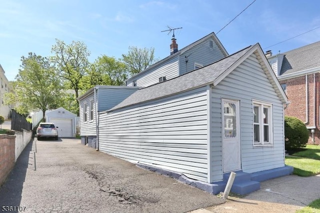 328 Hoover Ave, Bloomfield Twp, NJ 07003 - view of home's exterior with a detached garage, an outdoor structure, a chimney, and a shingled roof