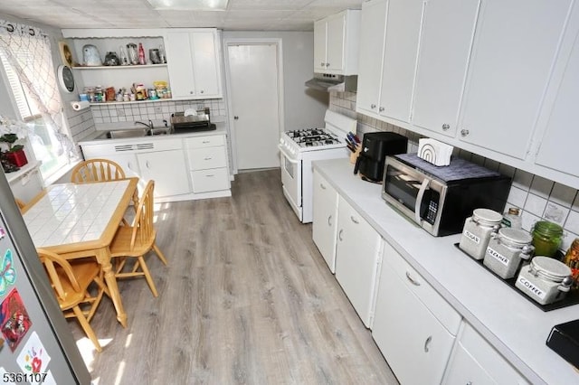 328 Hoover Ave, Bloomfield Twp, NJ 07003 - kitchen with appliances with stainless steel finishes, tasteful backsplash, light wood-type flooring, white cabinetry, and light countertops