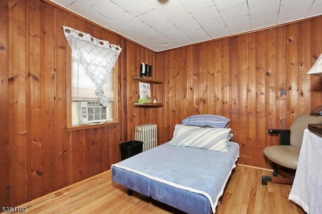 328 Hoover Ave, Bloomfield Twp, NJ 07003 - bedroom with radiator heating unit, wood walls, cooling unit, and wood finished floors