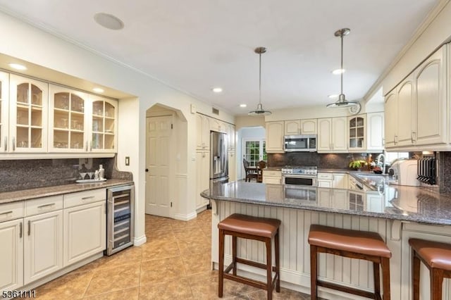 28 Sherbrook Dr, Berkeley Heights Twp, NJ 07922 - kitchen featuring appliances with stainless steel finishes, wine cooler, a peninsula, decorative backsplash, and crown molding