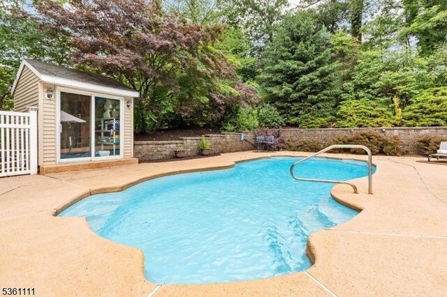 28 Sherbrook Dr, Berkeley Heights Twp, NJ 07922 - view of swimming pool featuring a patio, an outbuilding, and view of wooded area