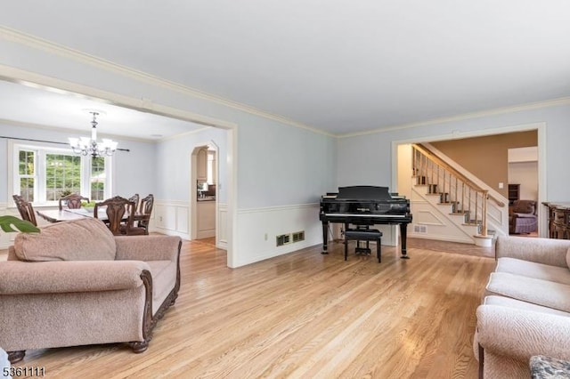 28 Sherbrook Dr, Berkeley Heights Twp, NJ 07922 - living area featuring a chandelier, light wood-type flooring, ornamental molding, stairs, and a wainscoted wall