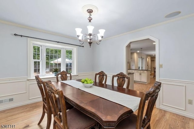 28 Sherbrook Dr, Berkeley Heights Twp, NJ 07922 - dining space featuring a chandelier, a wainscoted wall, a decorative wall, light wood finished floors, and crown molding