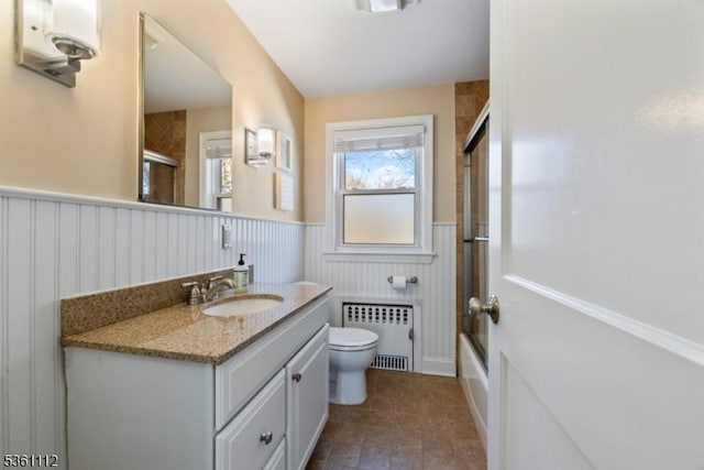13 Henley Ave, Cranford Twp, NJ 07016 - full bathroom with radiator heating unit, wainscoting, toilet, vanity, and shower / bath combination with glass door