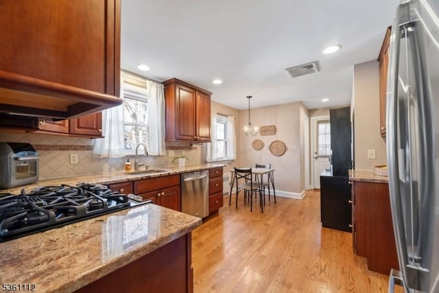 13 Henley Ave, Cranford Twp, NJ 07016 - kitchen featuring stainless steel appliances, a sink, tasteful backsplash, light stone countertops, and light wood-style flooring