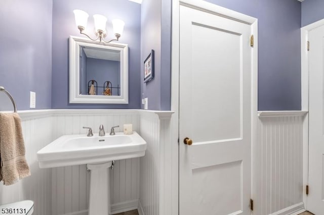 498 Pines Lake Dr, Wayne Twp, NJ 07470 - half bathroom featuring a wainscoted wall, a sink, and a decorative wall
