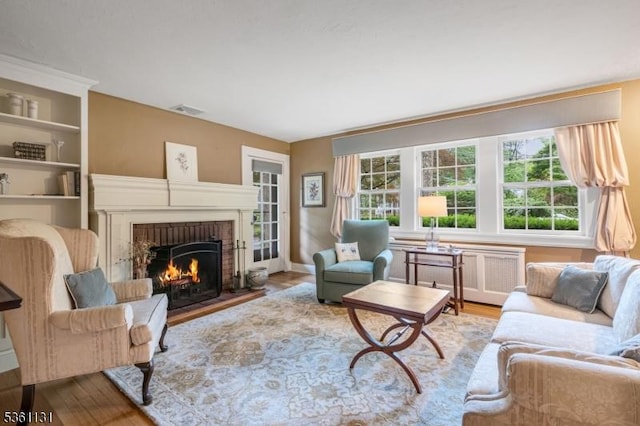 498 Pines Lake Dr, Wayne Twp, NJ 07470 - living area featuring a brick fireplace, wood finished floors, and baseboards