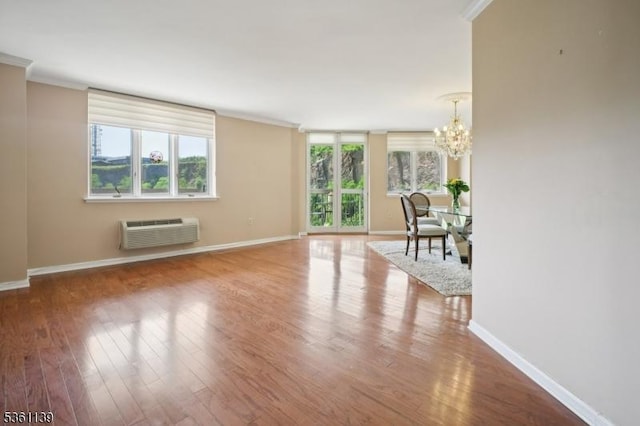 10 Smith Manor Blvd Unit 514, West Orange Twp, NJ 07052 - living room featuring an AC wall unit, a chandelier, baseboards, wood finished floors, and ornamental molding