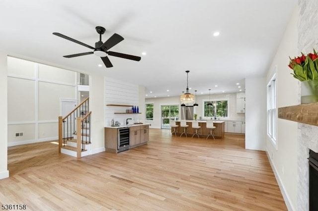 48 Hunterdon Blvd, Berkeley Heights Twp, NJ 07974 - living area with beverage cooler, a high end fireplace, light wood-type flooring, a ceiling fan, and stairway