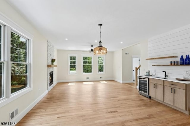 48 Hunterdon Blvd, Berkeley Heights Twp, NJ 07974 - kitchen featuring wine cooler, a fireplace, pendant lighting, open shelves, and light wood finished floors