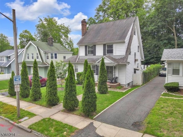 53 Elliot Pl, East Orange City, NJ 07018 - view of front of house with a chimney, a front lawn, and roof with shingles
